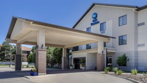 A Best Western hotel with a covered entrance, brick pillars, and potted plants. - Best Western North Edge Inn (Dodge City)