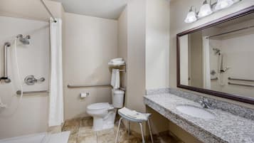 A bathroom with a shower, toilet, and sink.