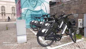 A row of bicycles parked in a designated area with a mural in the background. - B&B Eco (Pompei)