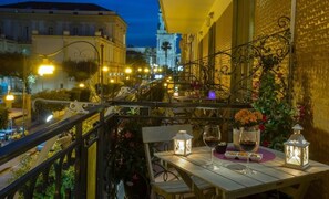 A balcony with a table set for dining, a lantern, and a wine glass. - B&B Eco (Pompei)