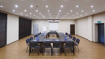 A conference room with a long table, chairs, and a whiteboard.