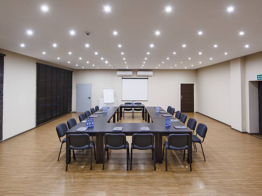 A conference room with a long table, chairs, and a whiteboard.