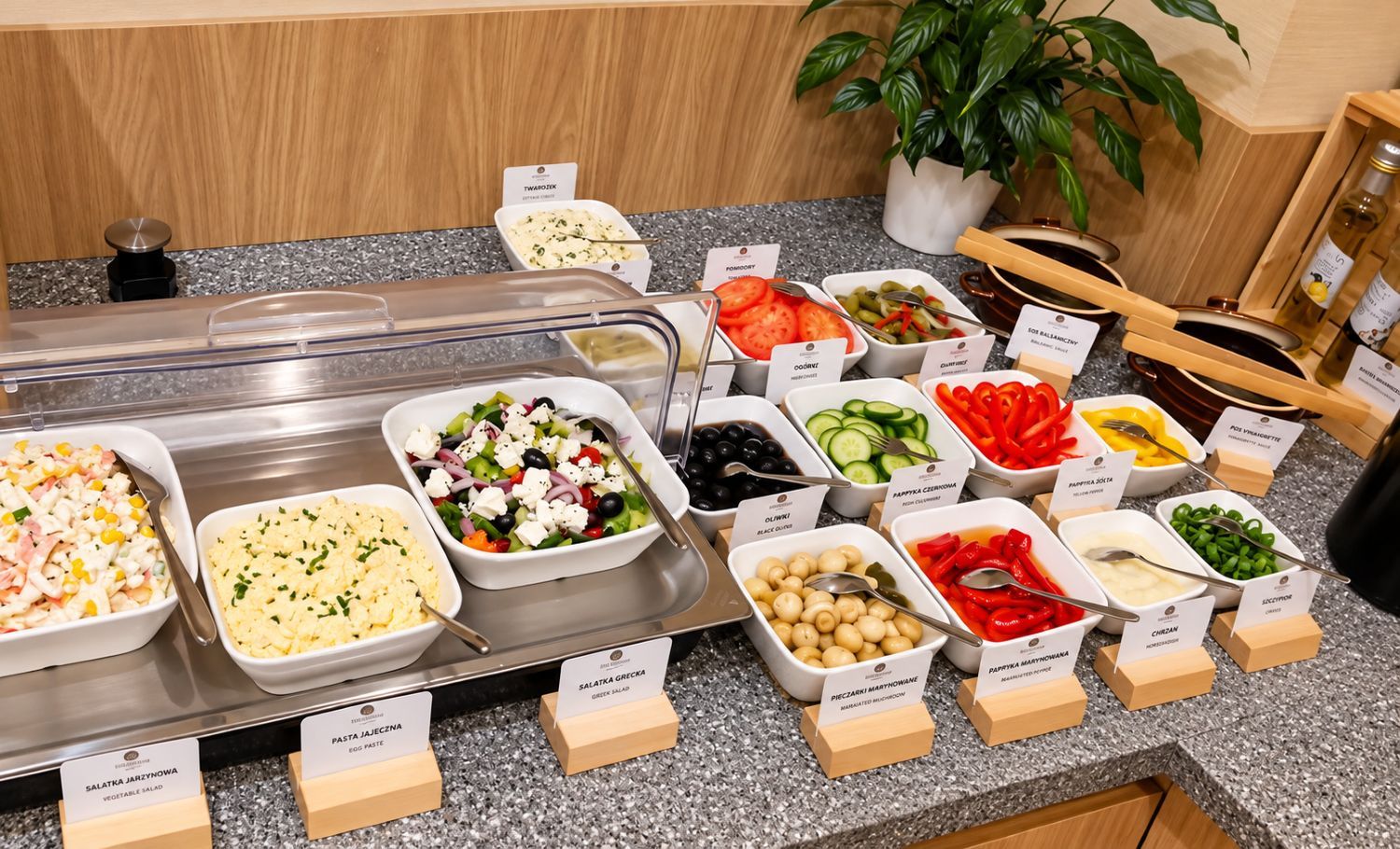 Un buffet proposant divers plats, notamment une salade grecque, une salade de légumes et des pâtes.