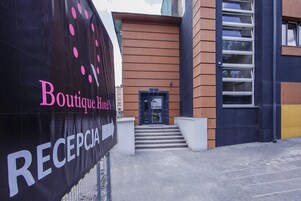 A hotel entrance with a sign for Boutique Hotel's Reception.