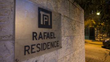 A sign for "RAFAEL RESIDENCE" mounted on a stone wall.