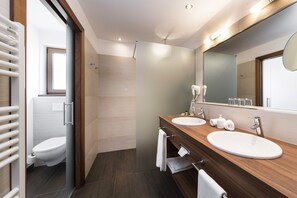 A modern bathroom with two sinks, a large mirror, and a shower. - Hotel Sulfner (Avelengo)