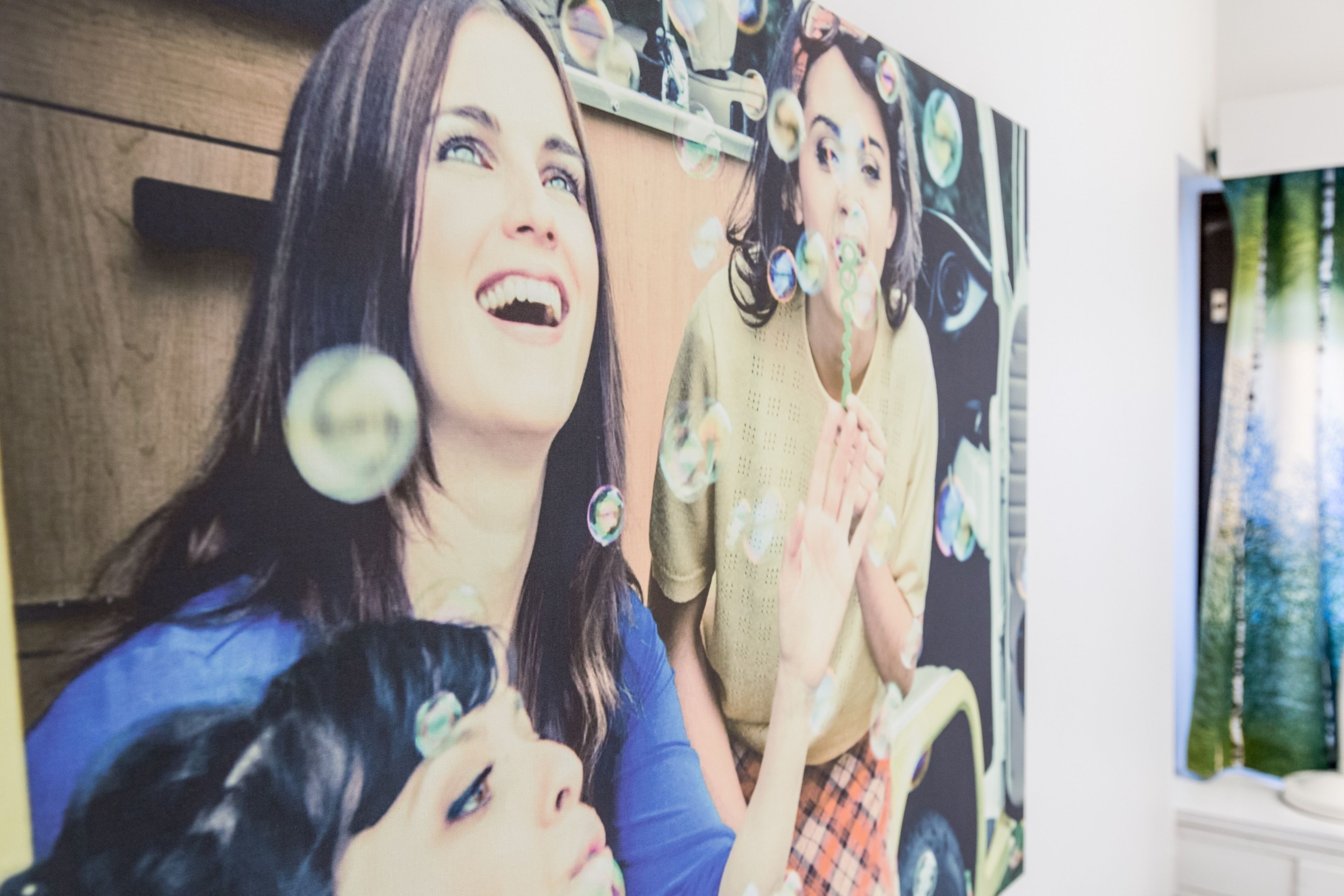 Una habitación con un cartel grande de dos personas soplando burbujas.
