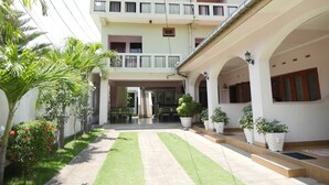A two-story building with a sign reading "Ocean View Tourist Guest House." There are outdoor seating areas and potted plants. - Ocean View Guesthouse (Negombo)