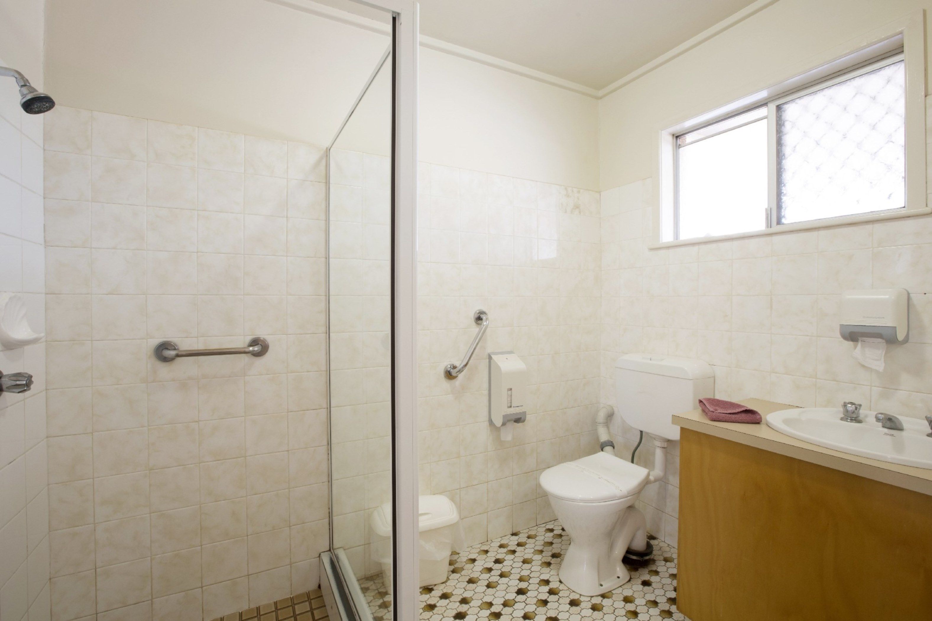 Un bagno con doccia, WC e lavandino.