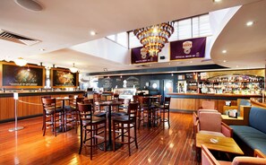 A bar area with wooden flooring, bar stools, and a high ceiling with a chandelier. - Wilsonton Hotel (Wilsonton)