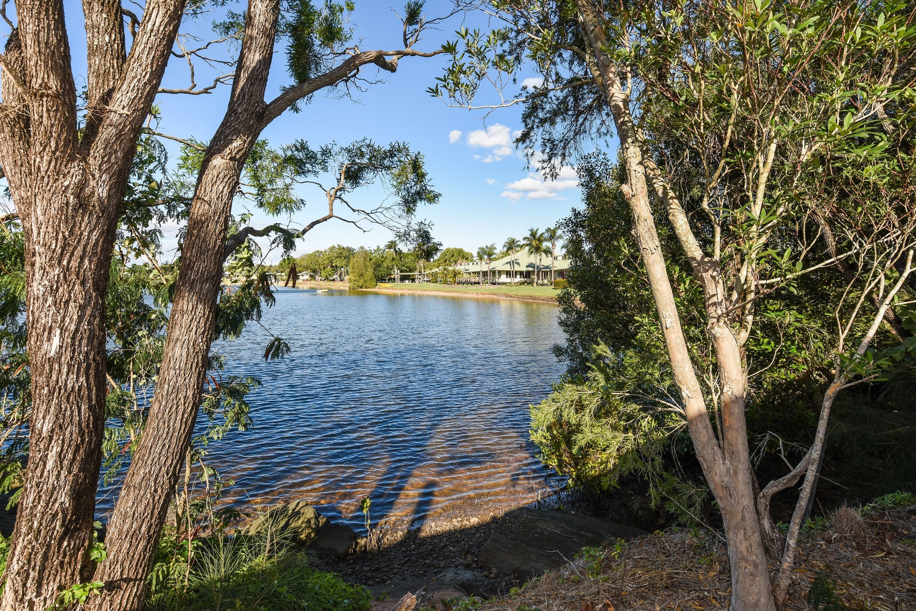 Un lago rodeado de árboles y un edificio con techo.