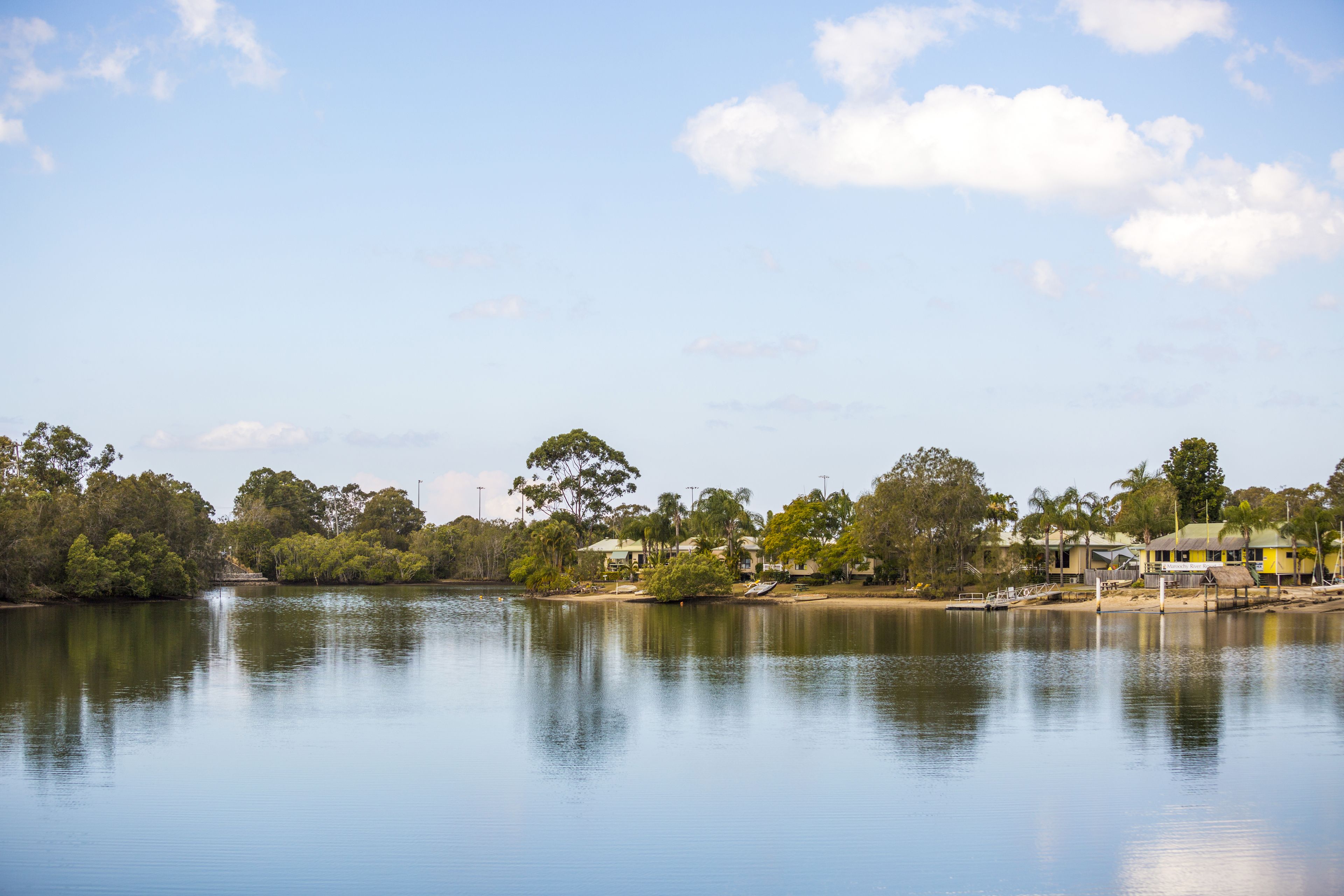 A calm lake with a row of houses along the shore.