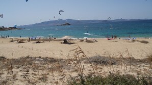 A beach with people, tents, and kites. - Diamantis Studios (Naxos)