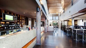 Un restaurant spacieux avec un long comptoir, de nombreuses tables et un bar bien fourni avec une grande variété de bouteilles.