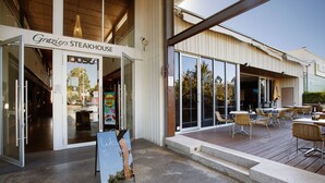 Le restaurant Graziers Steakhouse propose des places assises en plein air et offre une vue dégagée sur l’intérieur.
