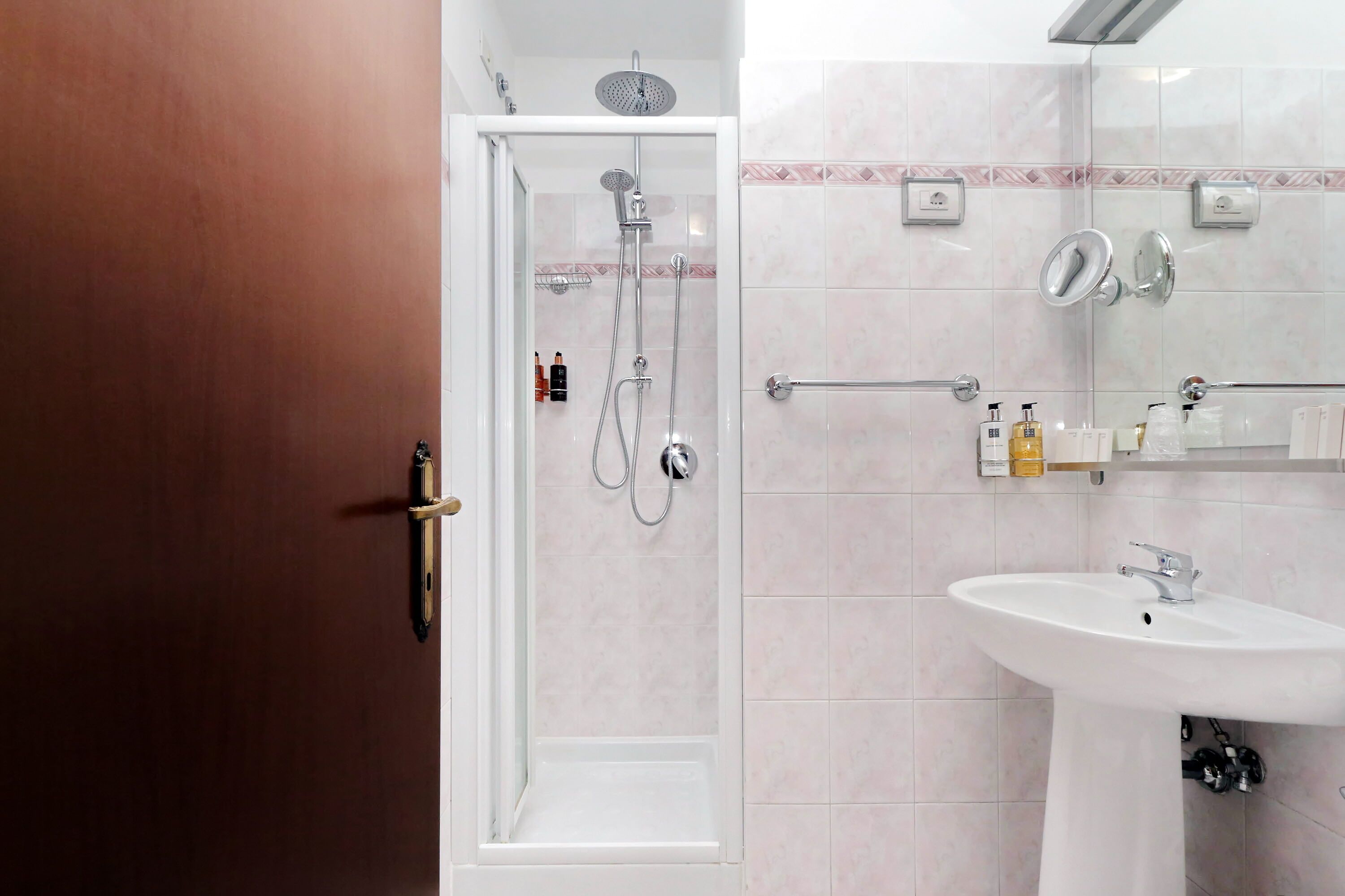 A modern bathroom with a walk-in shower, a sink, and a mirror.