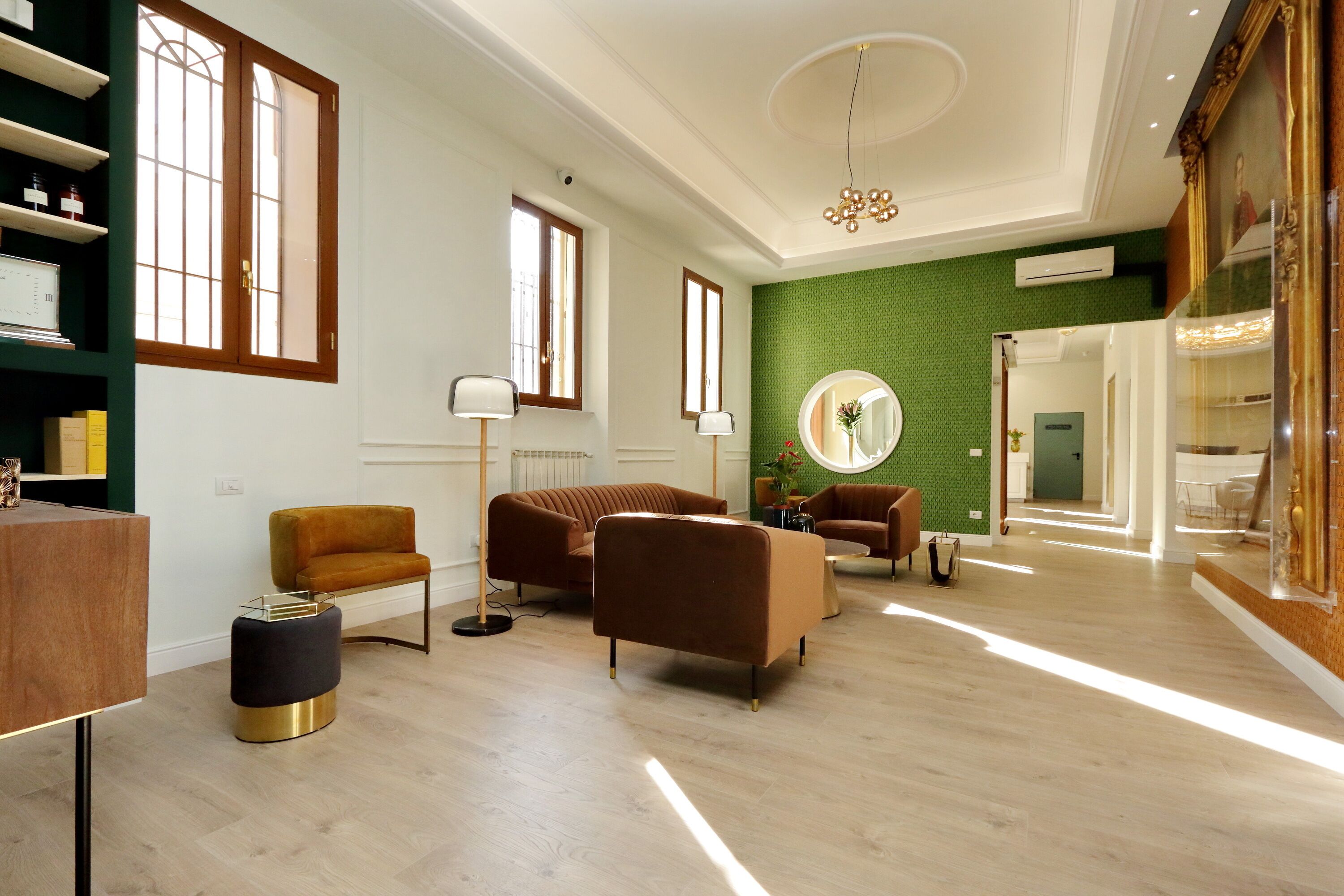 A spacious living area with a high ceiling, wooden flooring, and modern furniture including sofas and a coffee table.