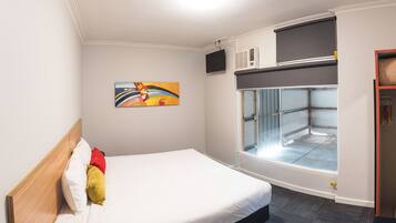 Habitación de hotel con cama, un cuadro, ventana con vistas, aire acondicionado y armario.