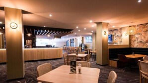 A restaurant with booths, tables, and a counter. - Links Hotel (Seaton)