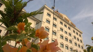 A hotel with a classic architectural style, featuring multiple windows and a prominent sign on the facade.