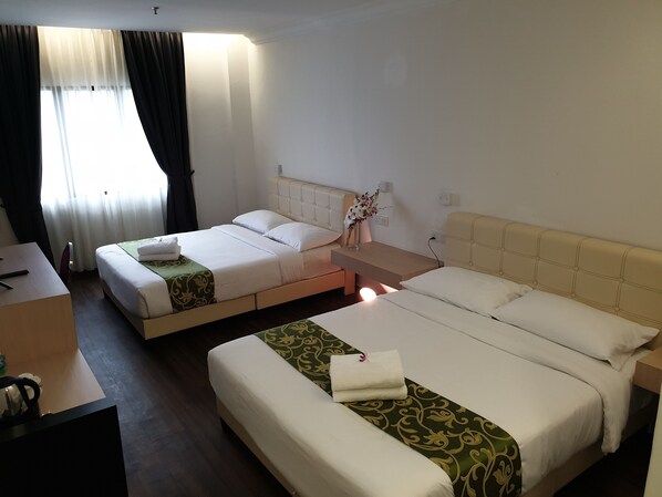 A hotel room with two beds, a desk, and a chair. - Fair Park Hotel (Ipoh)