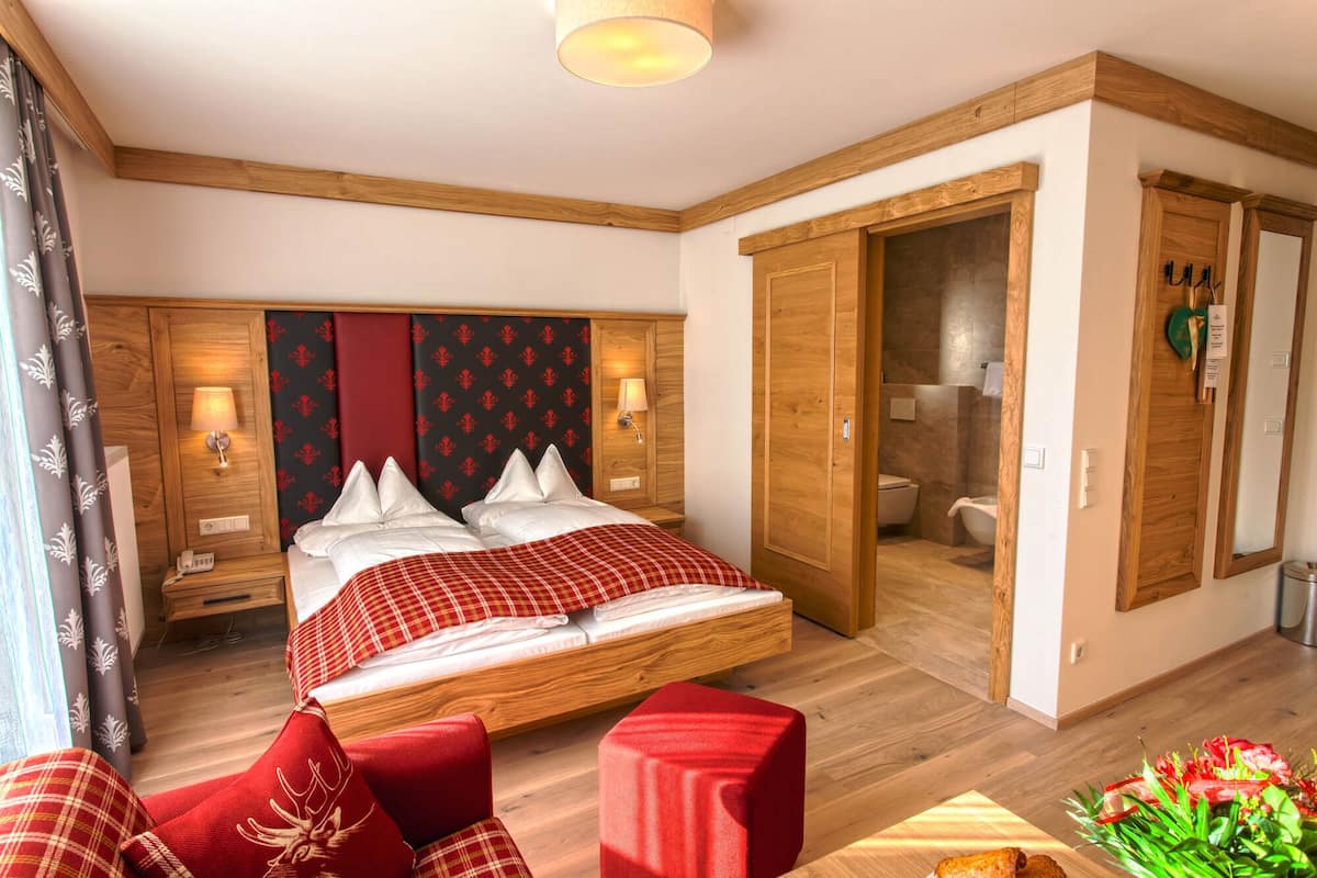 A bedroom with a bed, bedside tables, a wardrobe, and a bathroom.