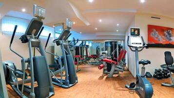 A gym with various exercise equipment, including treadmills, elliptical machines, and weight machines.