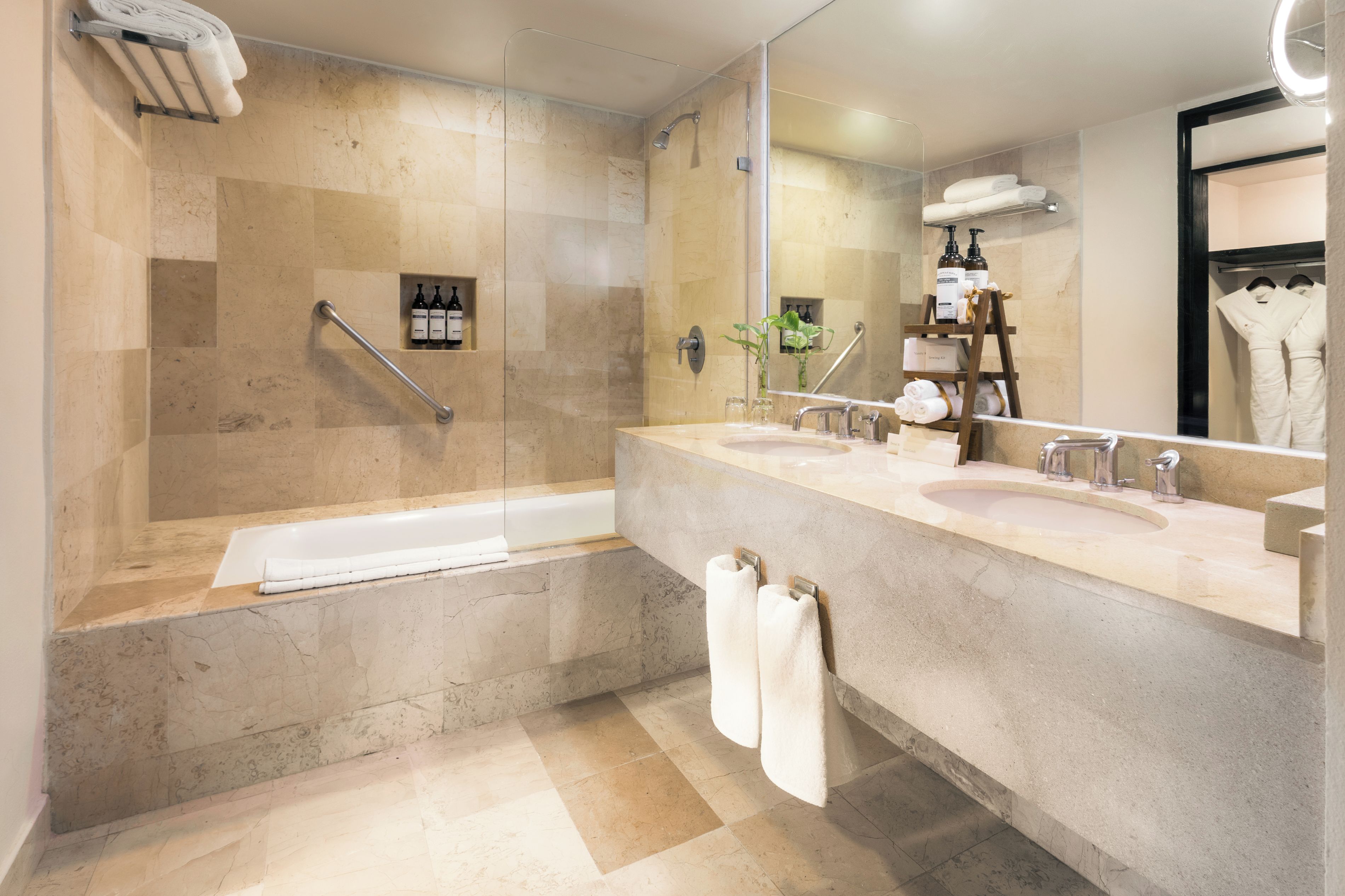 A modern bathroom with a walk-in shower, a bathtub, and a vanity with a large mirror.