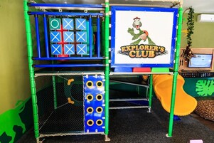 Un área de juegos con una estructura para escalar, un tobogán y un letrero que dice 