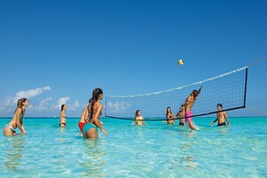 Un partido de voleibol de playa en aguas azul turquesa.