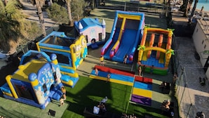 An outdoor play area with inflatable structures, including slides and a castle-themed playhouse. - Sporting Club Village (Mazara del Vallo)