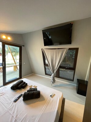 A bedroom with a bed, a TV mounted on the wall, and a window with curtains. - Sporting Club Village (Mazara del Vallo)
