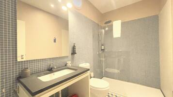 Un baño con lavamanos, inodoro y ducha.