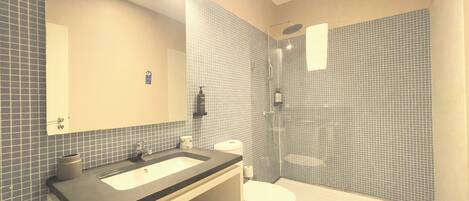 Une salle de bain avec un lavabo, des toilettes et une douche.