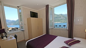 Hotelkamer met een bed, een bureau, een televisie en uitzicht op zee.