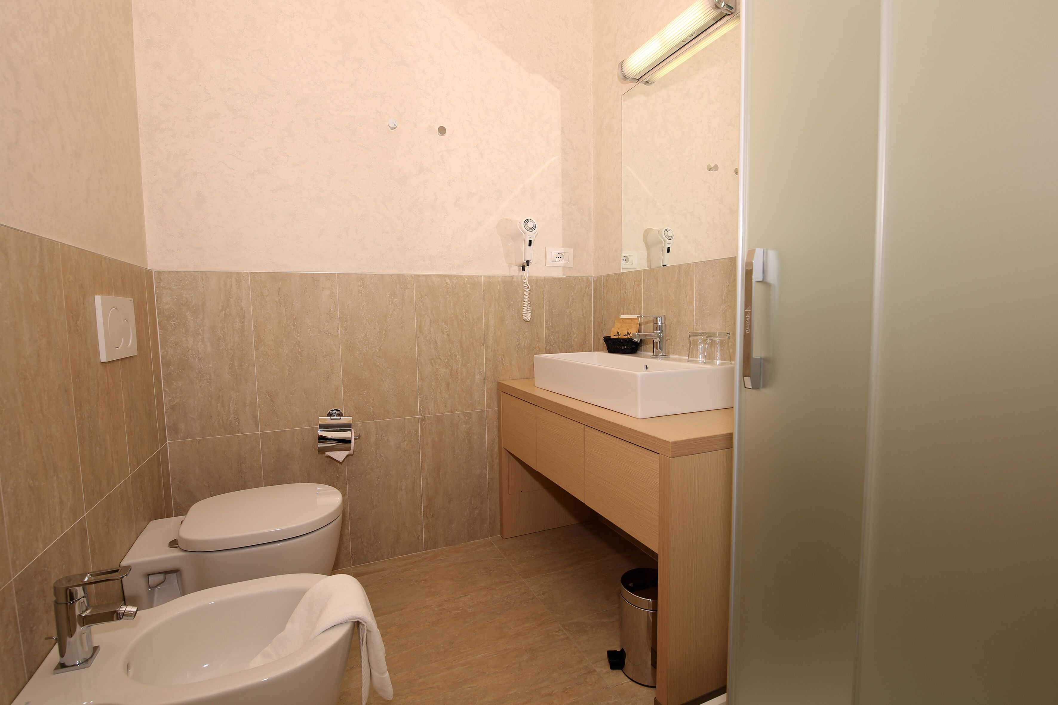 Et moderne badeværelse med toilet, vask og badekar.