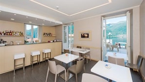 Een moderne hotelkamer met een bar, zitgedeelte en balkon met uitzicht.