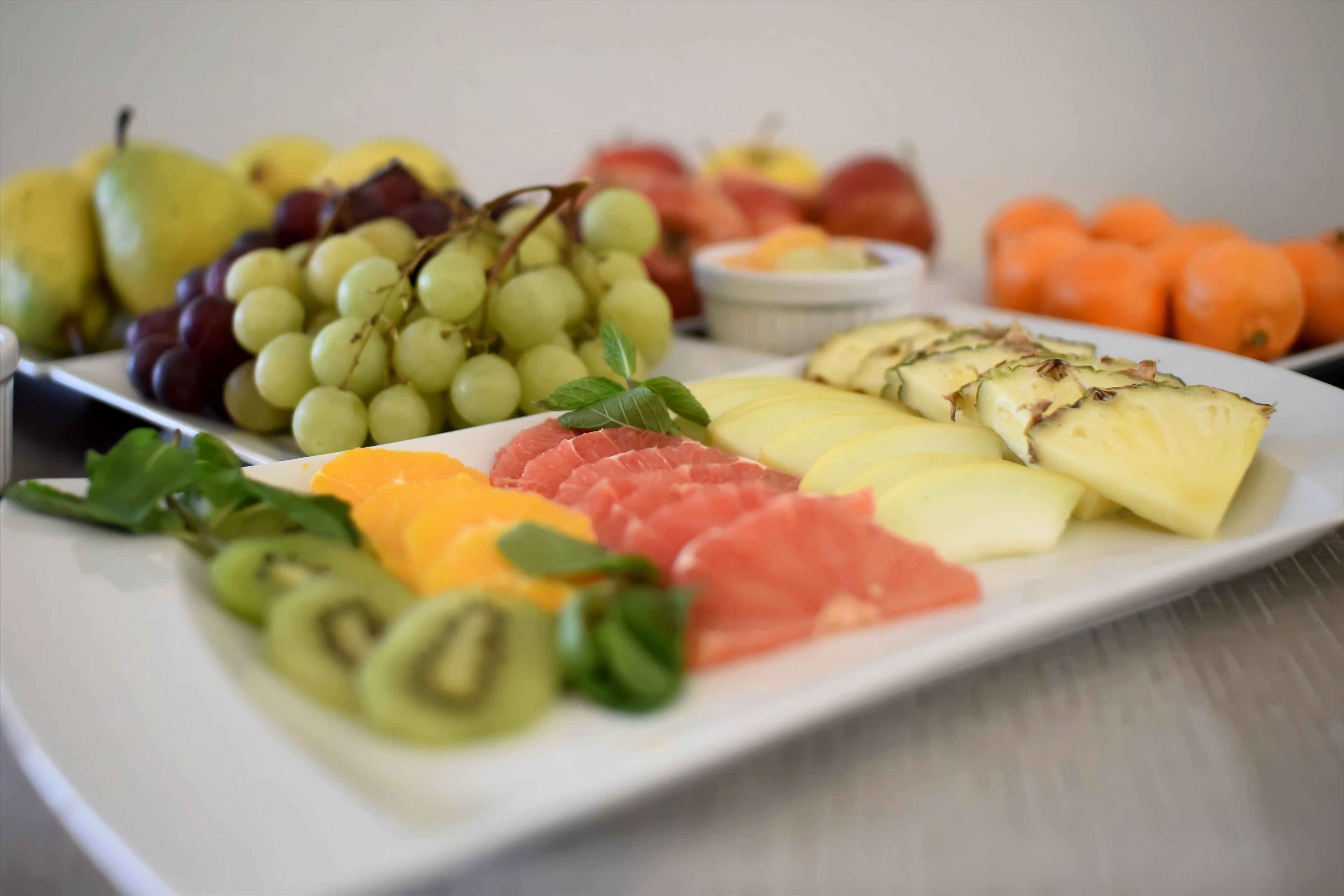 Un vassoio di frutta assortita con uva, kiwi, anguria e ananas.