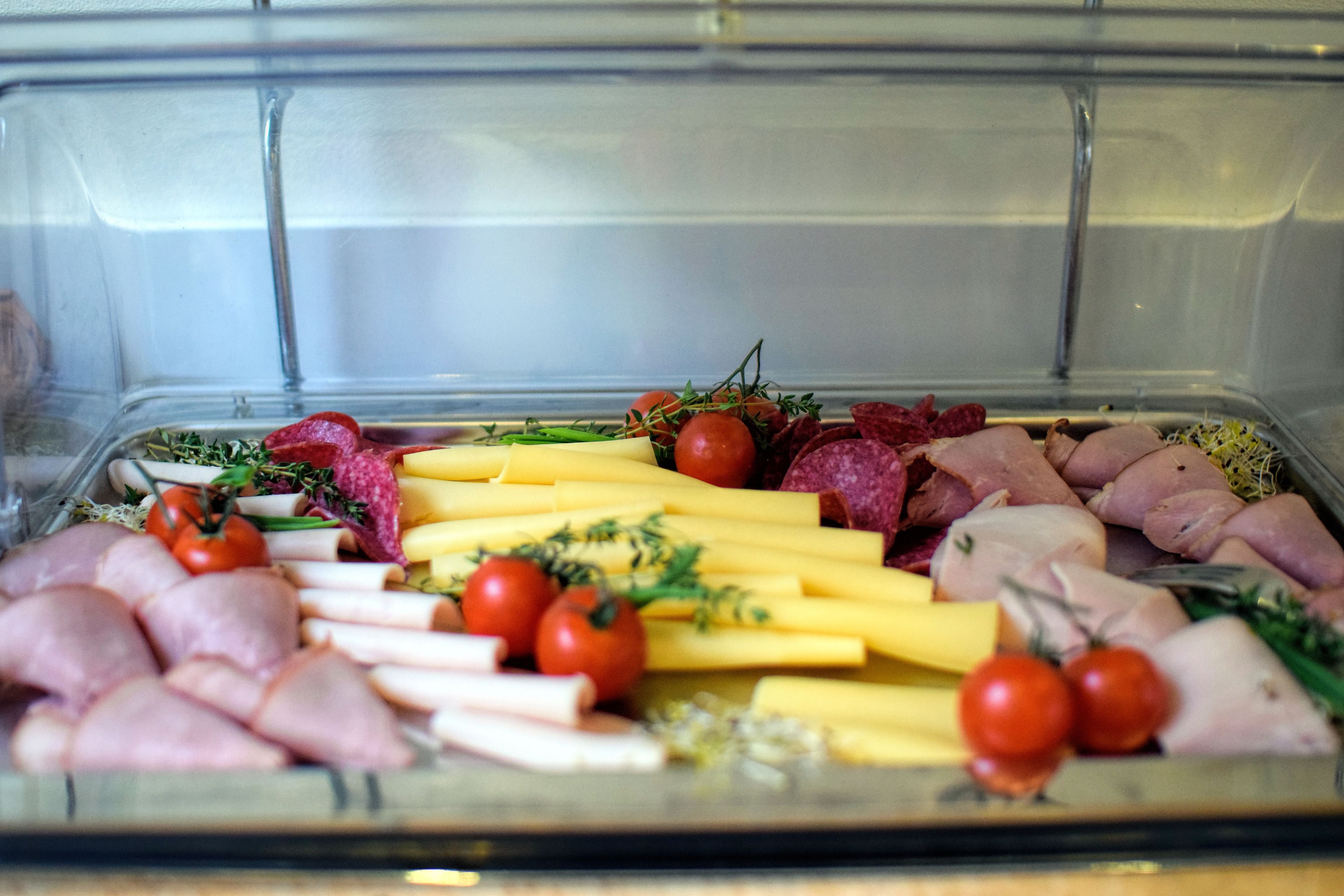 A charcuterie board with various meats, cheeses, and vegetables.
