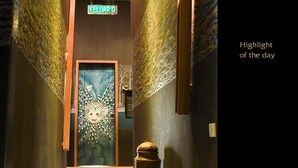 Un pasillo con paredes decoradas, suelo de madera y una puerta de diseño original.