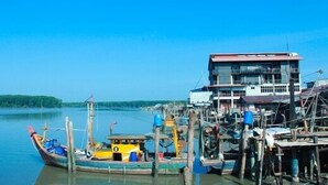 Un muelle con un bote y un edificio de varios pisos.
