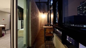 A narrow corridor with a brick wall, a wooden bench, and a table. - Queens Hotel Seomyeon Busan (Busan)