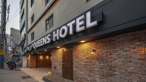A hotel entrance with a sign reading "Queens Hotel." - Queens Hotel Seomyeon Busan (Busan)