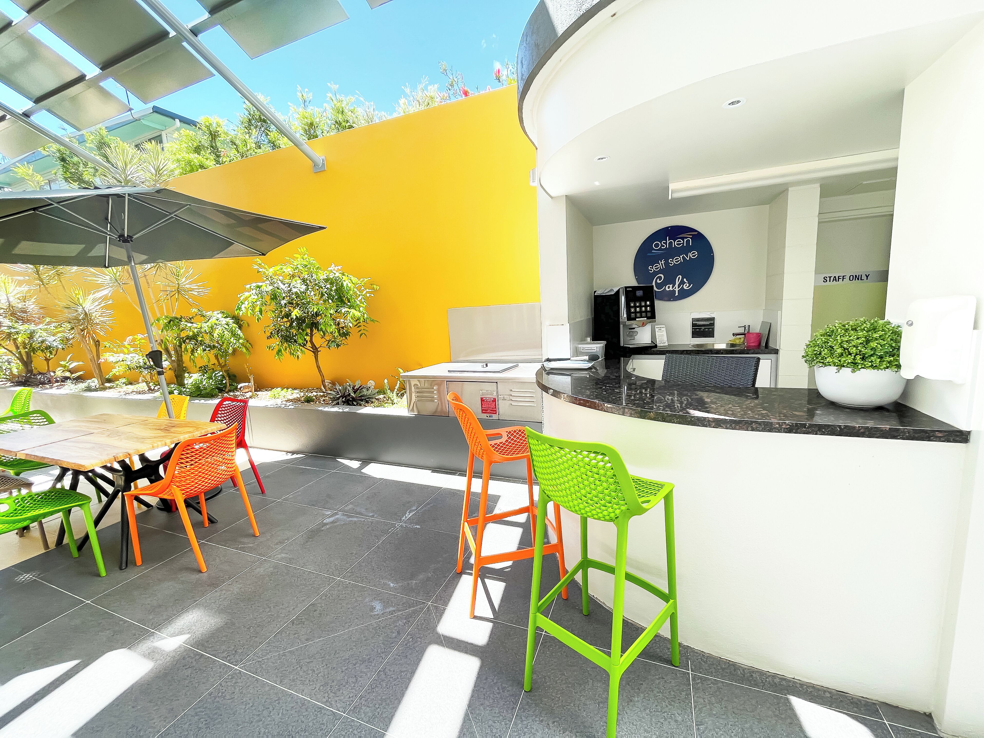A café with outdoor seating, a counter, and a sign indicating it is staff only.