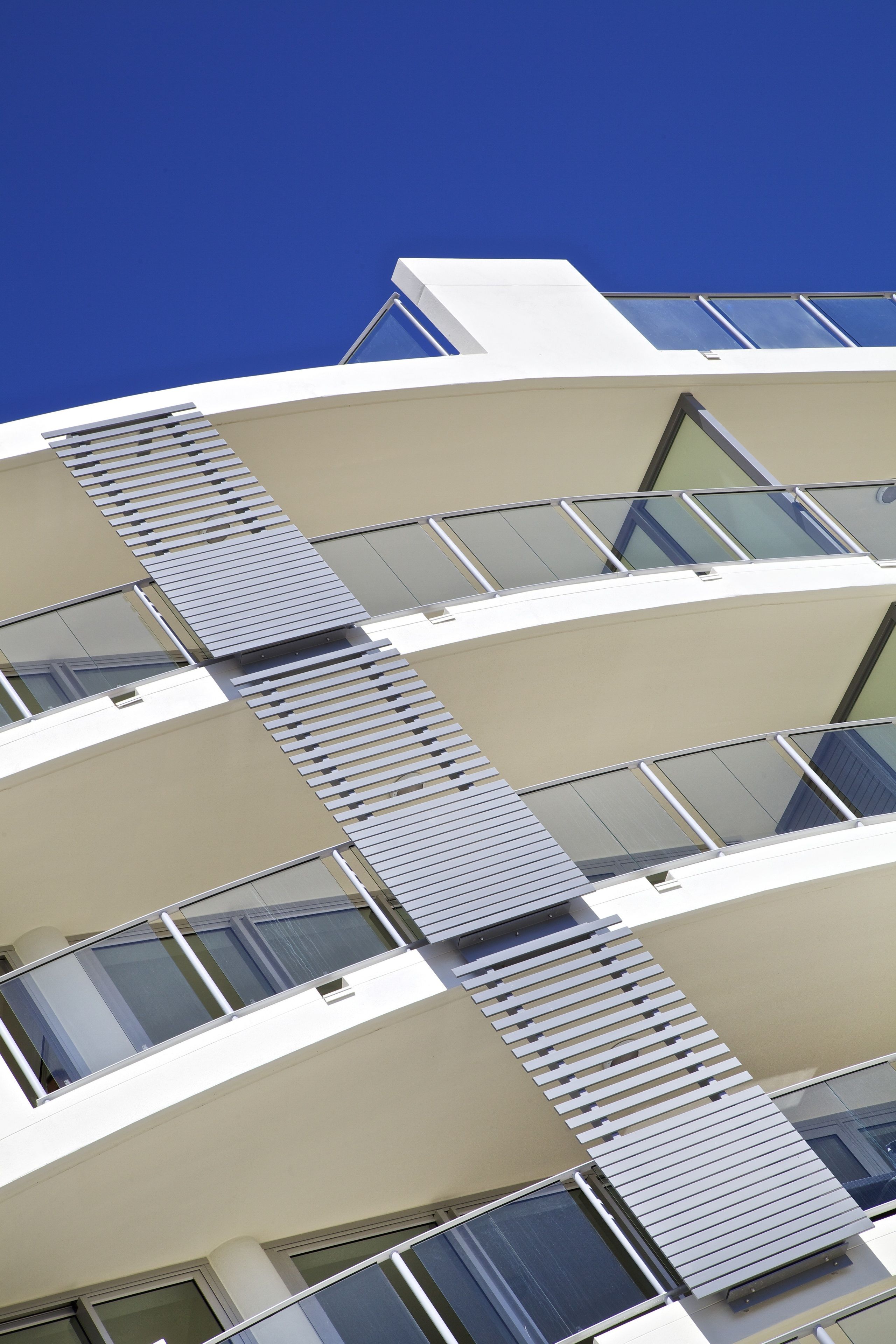 A modern building with multiple balconies and large windows.