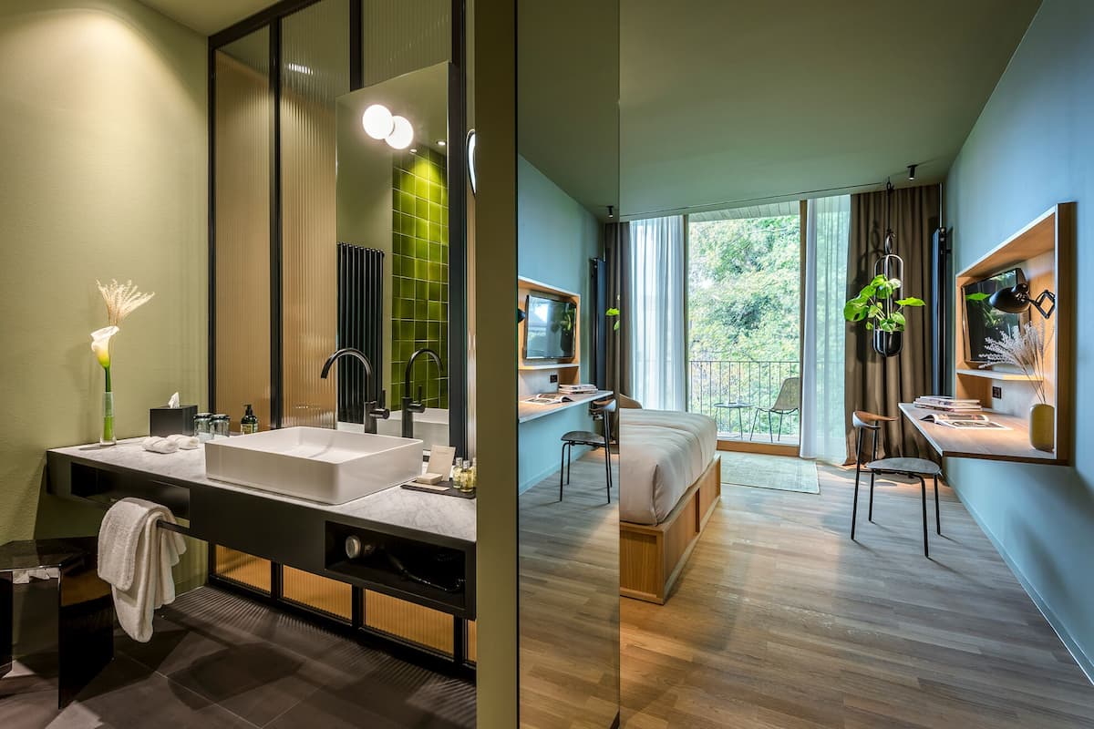 A modern bathroom with a large mirror, dual sinks, and a vanity.