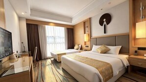 A hotel room with two beds, a desk, a TV, and a large window with curtains.
