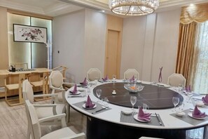 A conference room with a round table, chairs, and a chandelier.