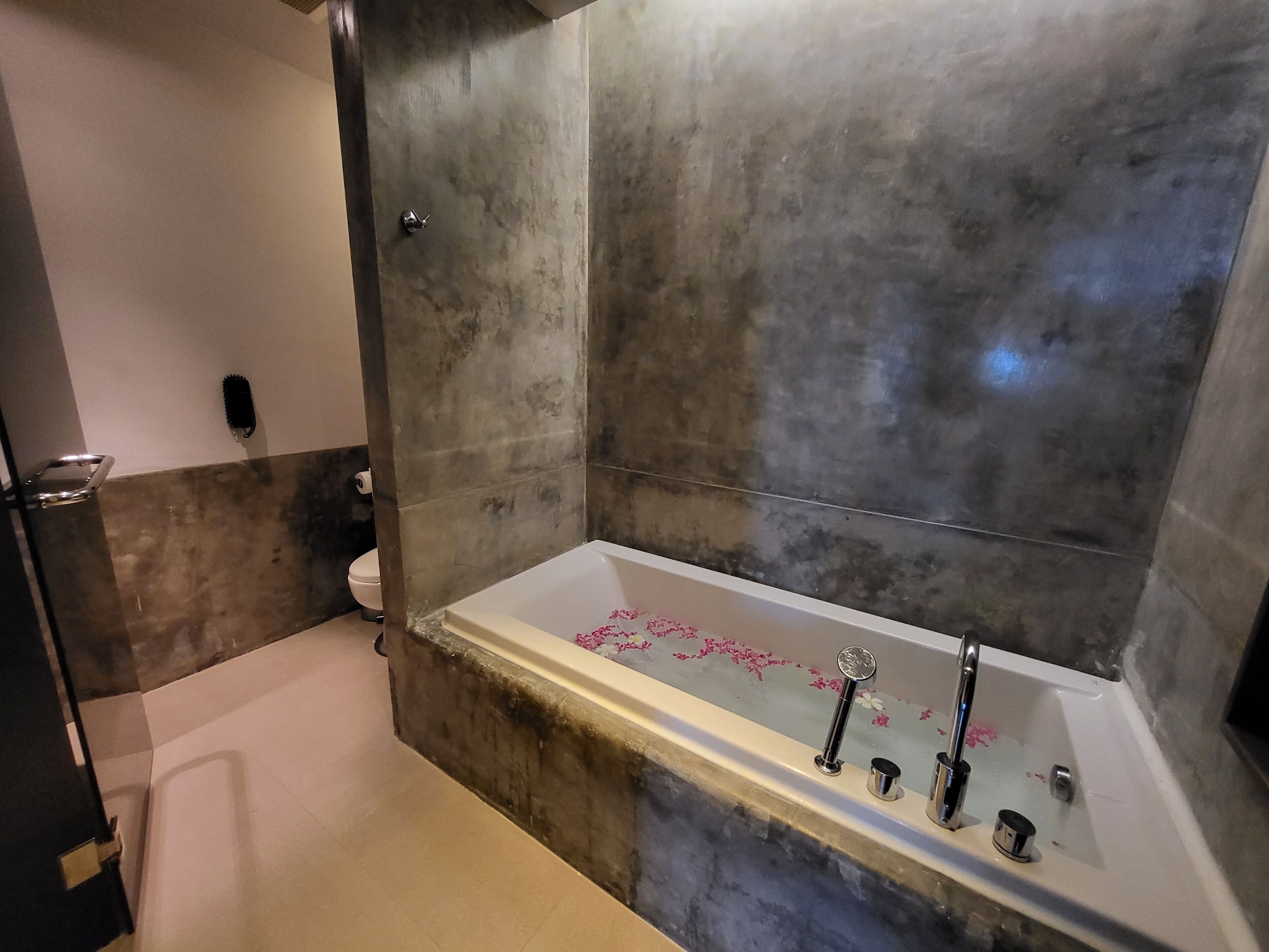 Une salle de bain moderne avec une grande baignoire, des toilettes et un espace douche.
