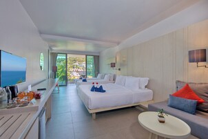 Una habitación de hotel con cama, sofá, una mesita y televisión.
